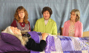 Threshold singers Lois Holub, Mathilda Wheeler and Marlene Ayala (left to right) practice singing at the bedside for Janis Walworth. 